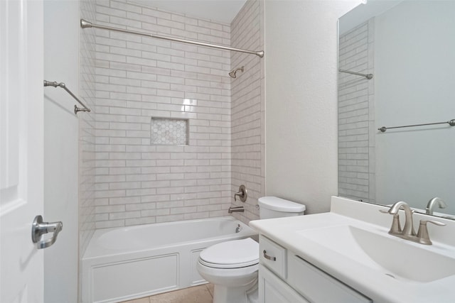 full bathroom with tile patterned floors, vanity, tiled shower / bath combo, and toilet