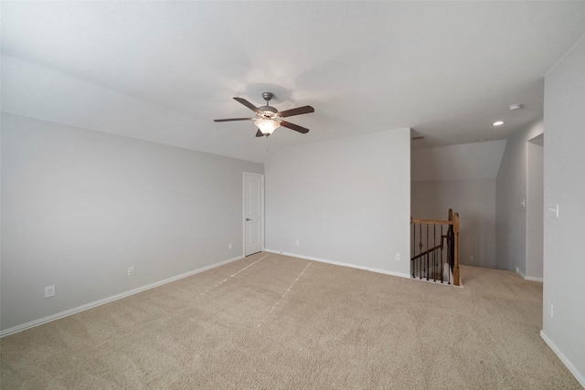 empty room featuring light carpet, vaulted ceiling, and ceiling fan