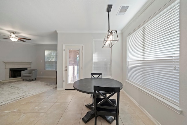 dining space featuring light tile patterned floors, plenty of natural light, crown molding, and ceiling fan