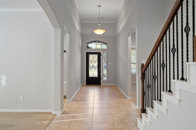 entrance foyer featuring plenty of natural light, light tile patterned flooring, and crown molding