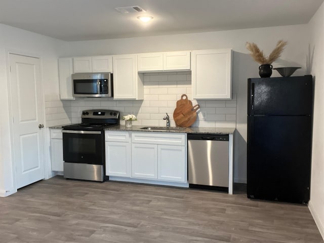 kitchen featuring decorative backsplash, white cabinetry, sink, and stainless steel appliances