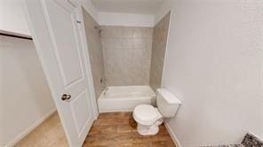 bathroom with a tile shower and toilet