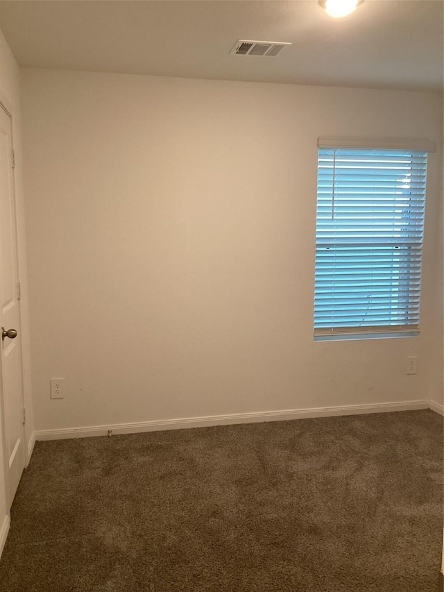 empty room with dark colored carpet