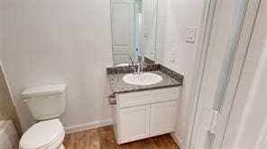 bathroom featuring vanity, hardwood / wood-style flooring, and toilet