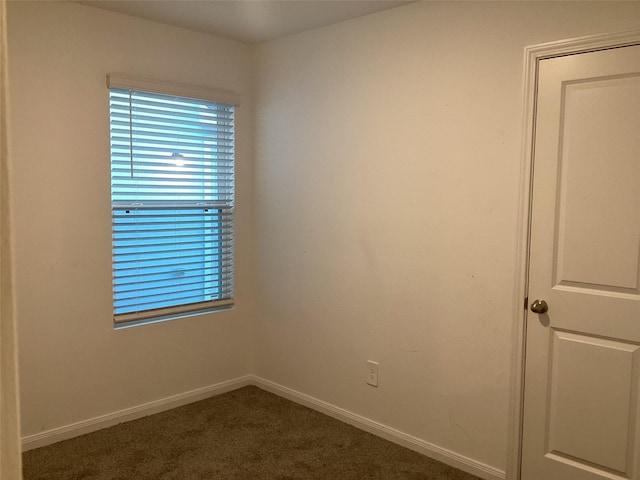 unfurnished room with dark colored carpet