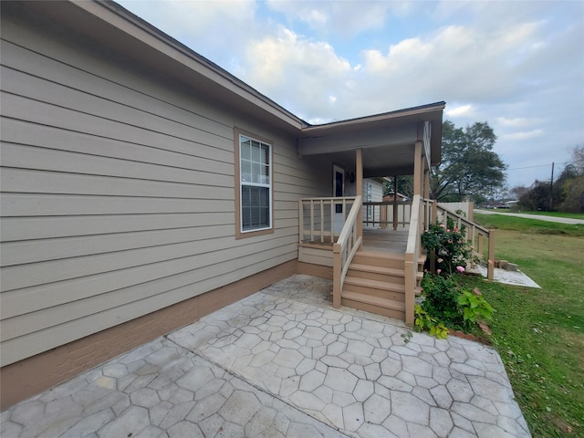 property entrance with a yard and a patio