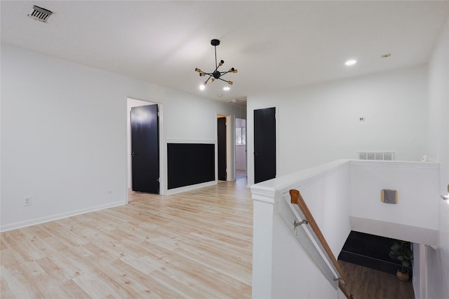 stairs with hardwood / wood-style flooring and a chandelier