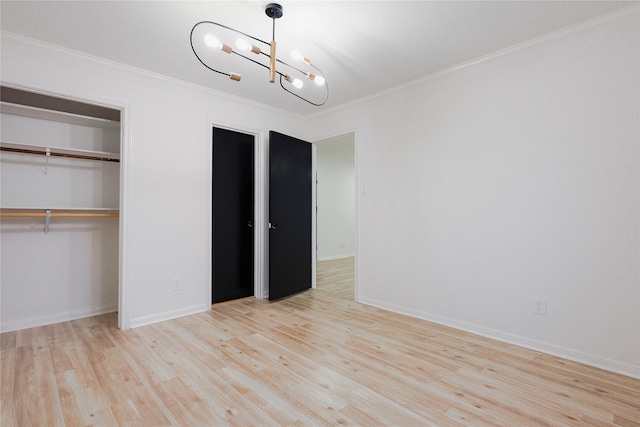 unfurnished bedroom featuring a notable chandelier, light hardwood / wood-style floors, ornamental molding, and a closet