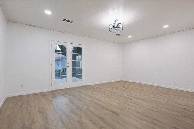 empty room with light hardwood / wood-style floors and french doors