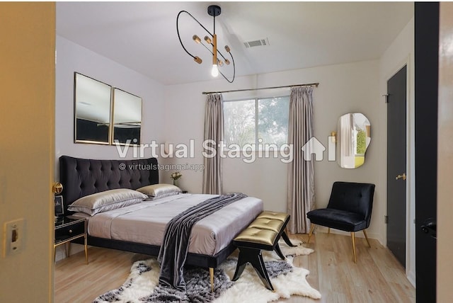 bedroom featuring light hardwood / wood-style floors and an inviting chandelier