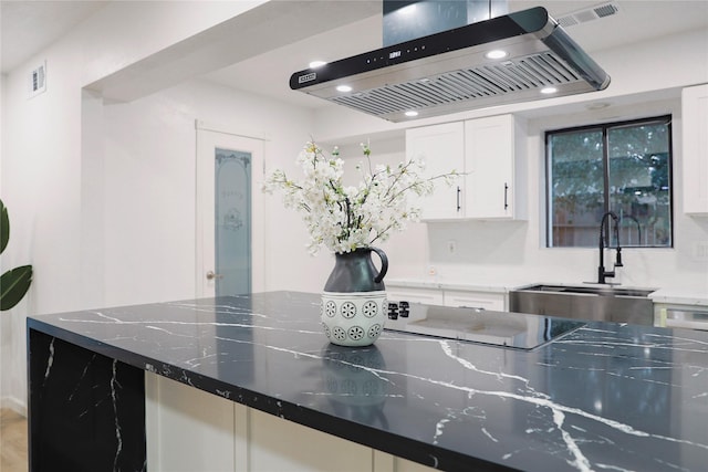 kitchen featuring white cabinets, dark stone countertops, sink, and exhaust hood