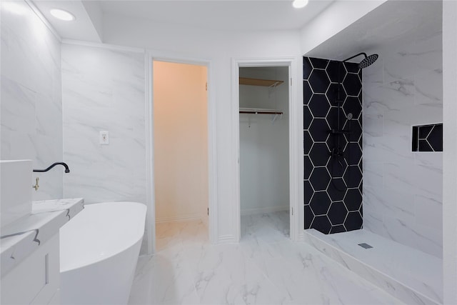 bathroom with tile walls and independent shower and bath