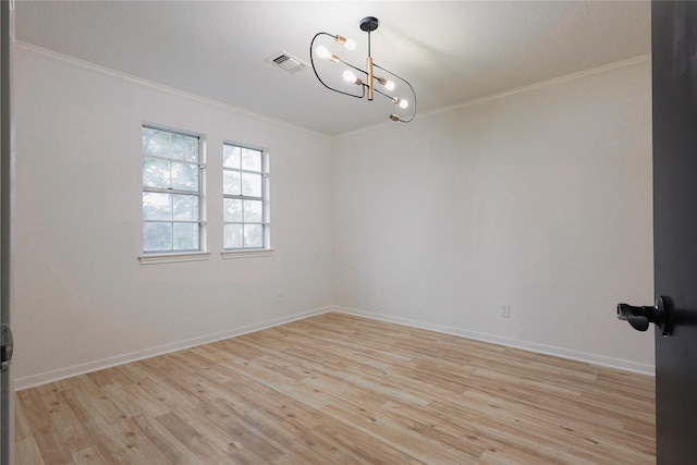 spare room with light hardwood / wood-style flooring, ornamental molding, and a notable chandelier