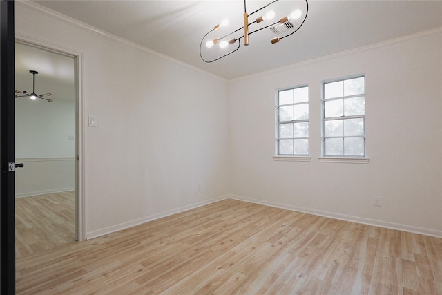 empty room featuring ceiling fan with notable chandelier, light hardwood / wood-style floors, and ornamental molding