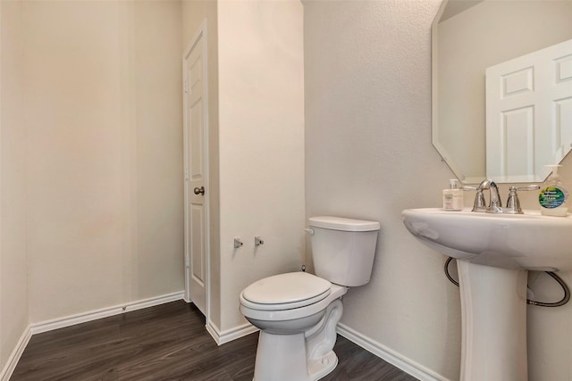 bathroom with toilet and hardwood / wood-style floors