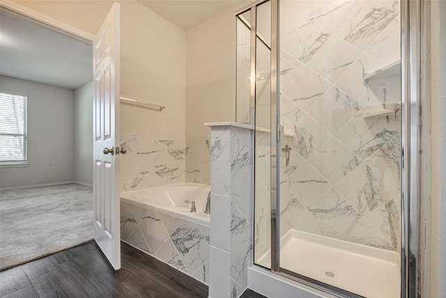 bathroom featuring wood-type flooring and shower with separate bathtub