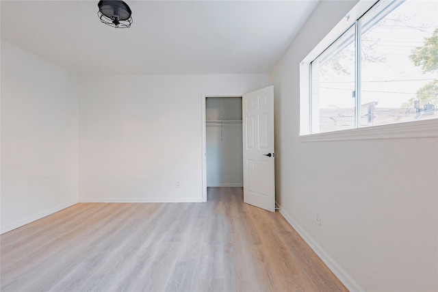 unfurnished bedroom with light hardwood / wood-style floors and a closet