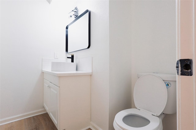 bathroom with hardwood / wood-style floors, vanity, and toilet