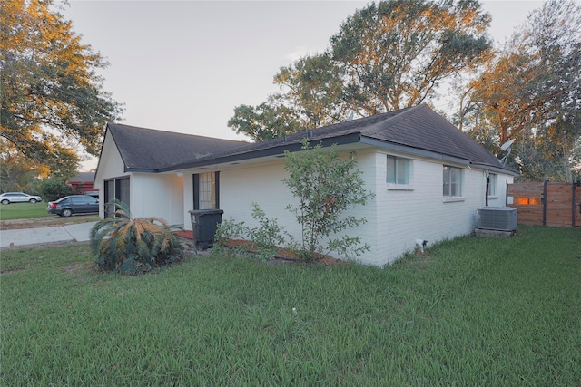 view of home's exterior with central AC and a lawn