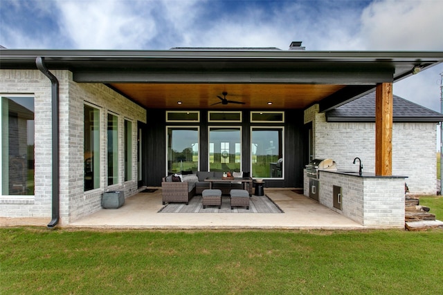 back of house featuring an outdoor living space, ceiling fan, sink, exterior kitchen, and a patio area