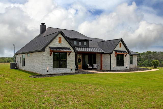 rear view of property with a yard and central AC