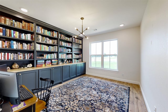 sitting room featuring light wood-type flooring and a notable chandelier