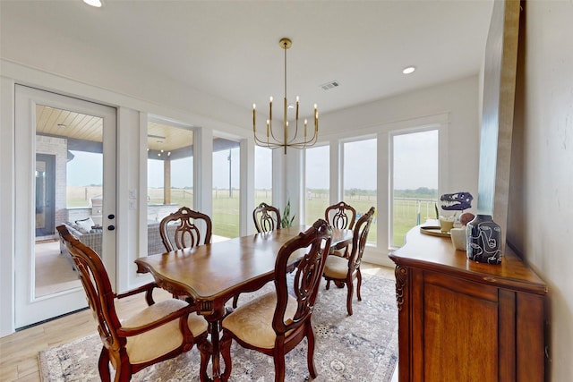 dining room featuring light wood-type flooring and a notable chandelier