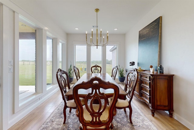 dining room featuring a chandelier, light wood-type flooring, and a healthy amount of sunlight