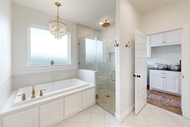 bathroom with independent shower and bath and an inviting chandelier