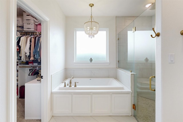 bathroom featuring tile patterned floors, separate shower and tub, and a chandelier