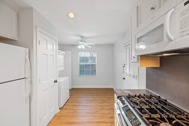 kitchen featuring white cabinetry, ceiling fan, light hardwood / wood-style floors, stacked washer / drying machine, and white appliances