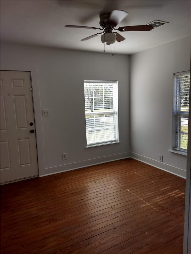 empty room with dark hardwood / wood-style flooring and ceiling fan