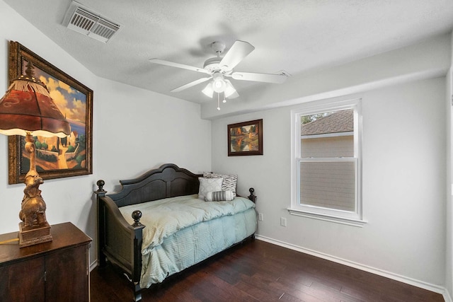 bedroom featuring ceiling fan, dark hardwood / wood-style flooring, and a textured ceiling