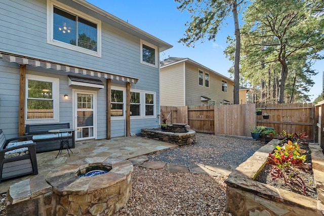 rear view of house with a patio and an outdoor fire pit