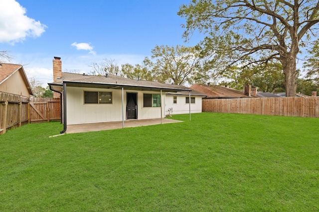 rear view of property with a lawn and a patio