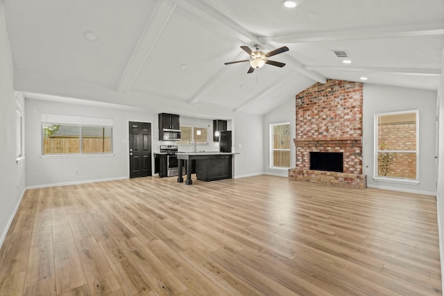 unfurnished living room with light hardwood / wood-style floors, ceiling fan, lofted ceiling with beams, and a brick fireplace