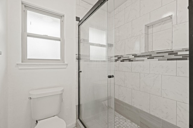 bathroom with an enclosed shower and toilet