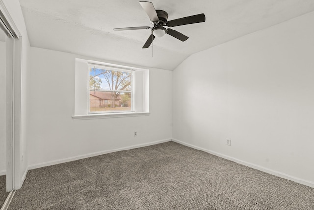 carpeted spare room with ceiling fan and lofted ceiling