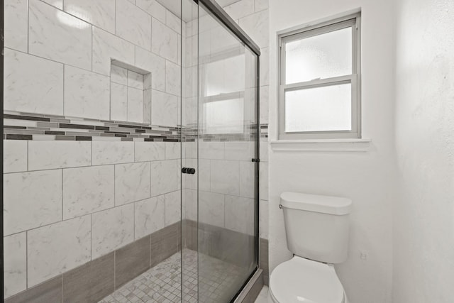 bathroom featuring an enclosed shower and toilet