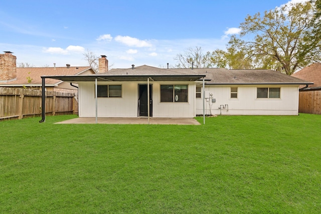 back of property with a lawn and a patio area