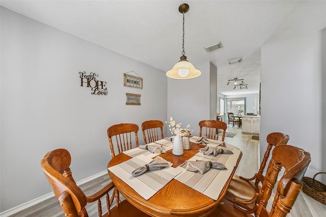 dining room featuring hardwood / wood-style floors and a textured ceiling