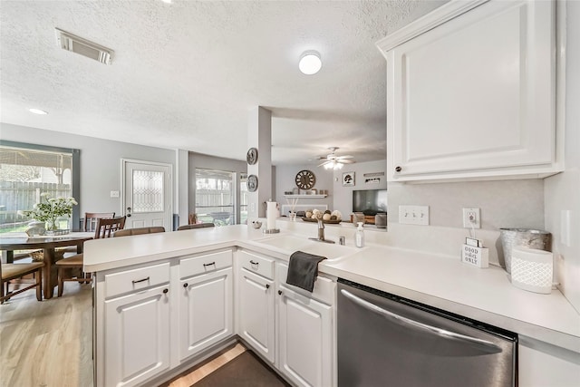 kitchen featuring kitchen peninsula, white cabinetry, stainless steel dishwasher, and ceiling fan