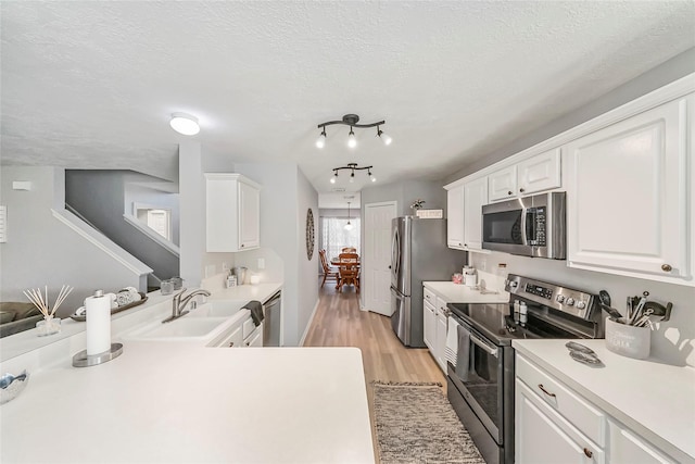 kitchen featuring white cabinets, sink, appliances with stainless steel finishes, and a textured ceiling