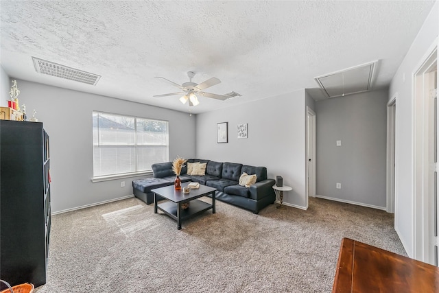 living room with ceiling fan, carpet floors, and a textured ceiling