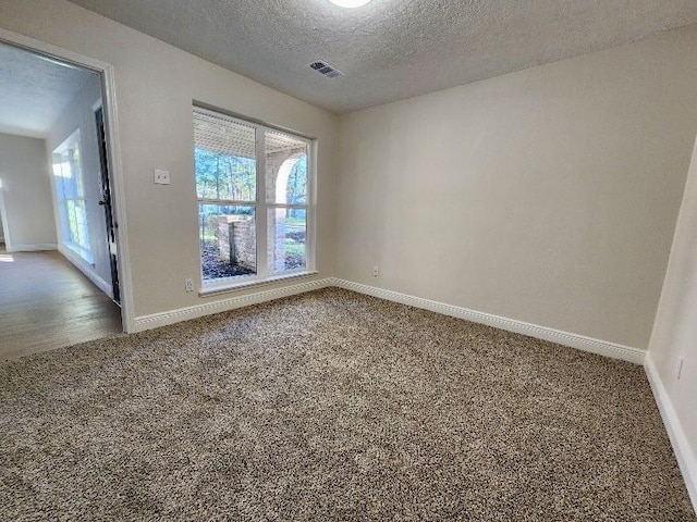 carpeted spare room featuring a textured ceiling