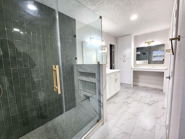 bathroom featuring a textured ceiling, a shower with door, and vanity