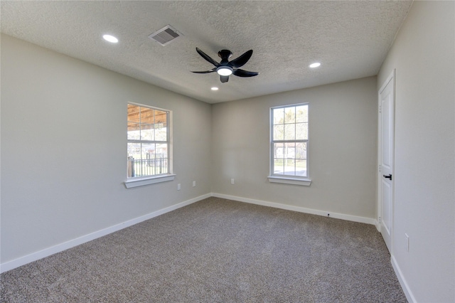 carpeted spare room with ceiling fan and a textured ceiling