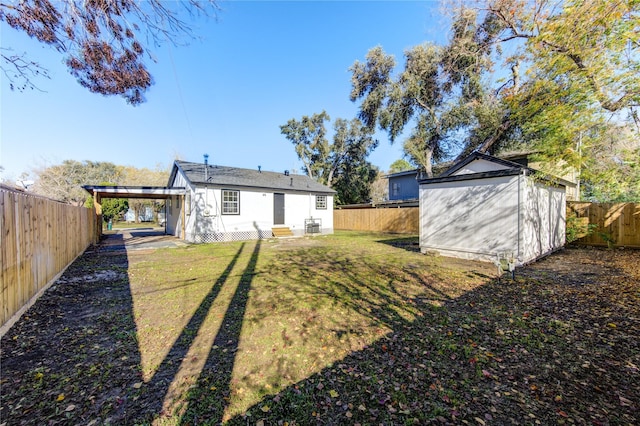 back of property featuring a yard, a shed, and a carport