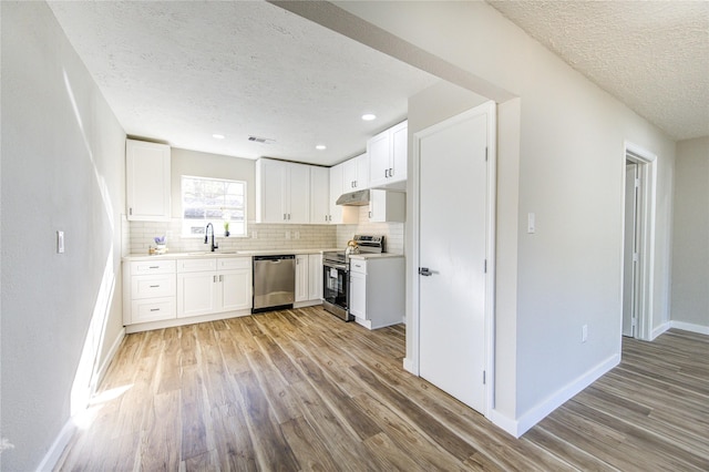 kitchen with white cabinets, appliances with stainless steel finishes, decorative backsplash, and sink