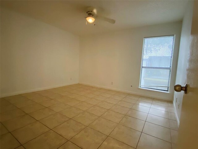 unfurnished room with ceiling fan and light tile patterned floors